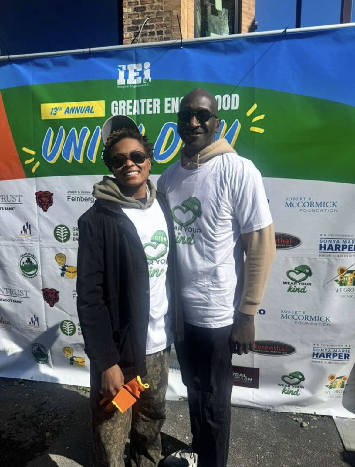 Two volunteers in front of the Unity Day banner